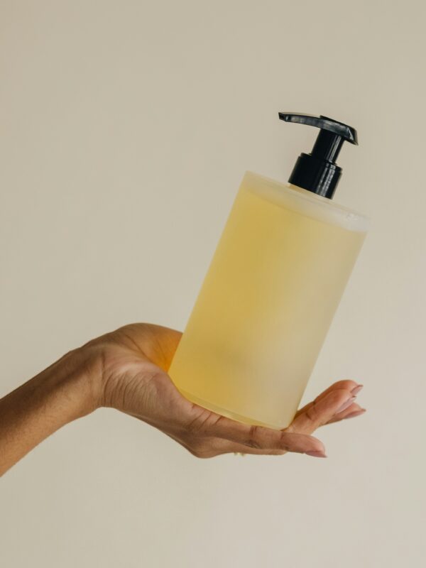Hand holding a bottle of conditioner in hand.