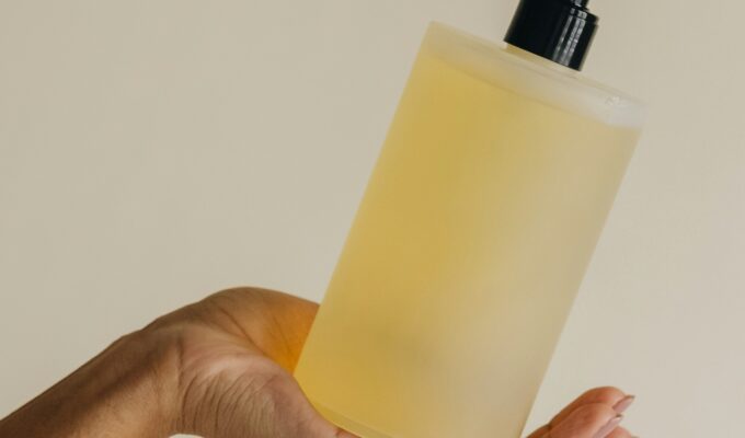 Hand holding a bottle of conditioner in hand.
