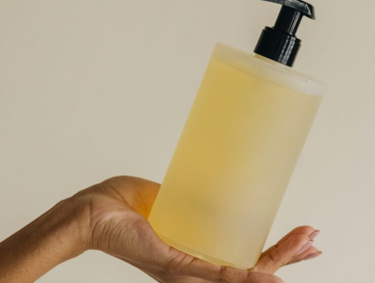 Hand holding a bottle of conditioner in hand.