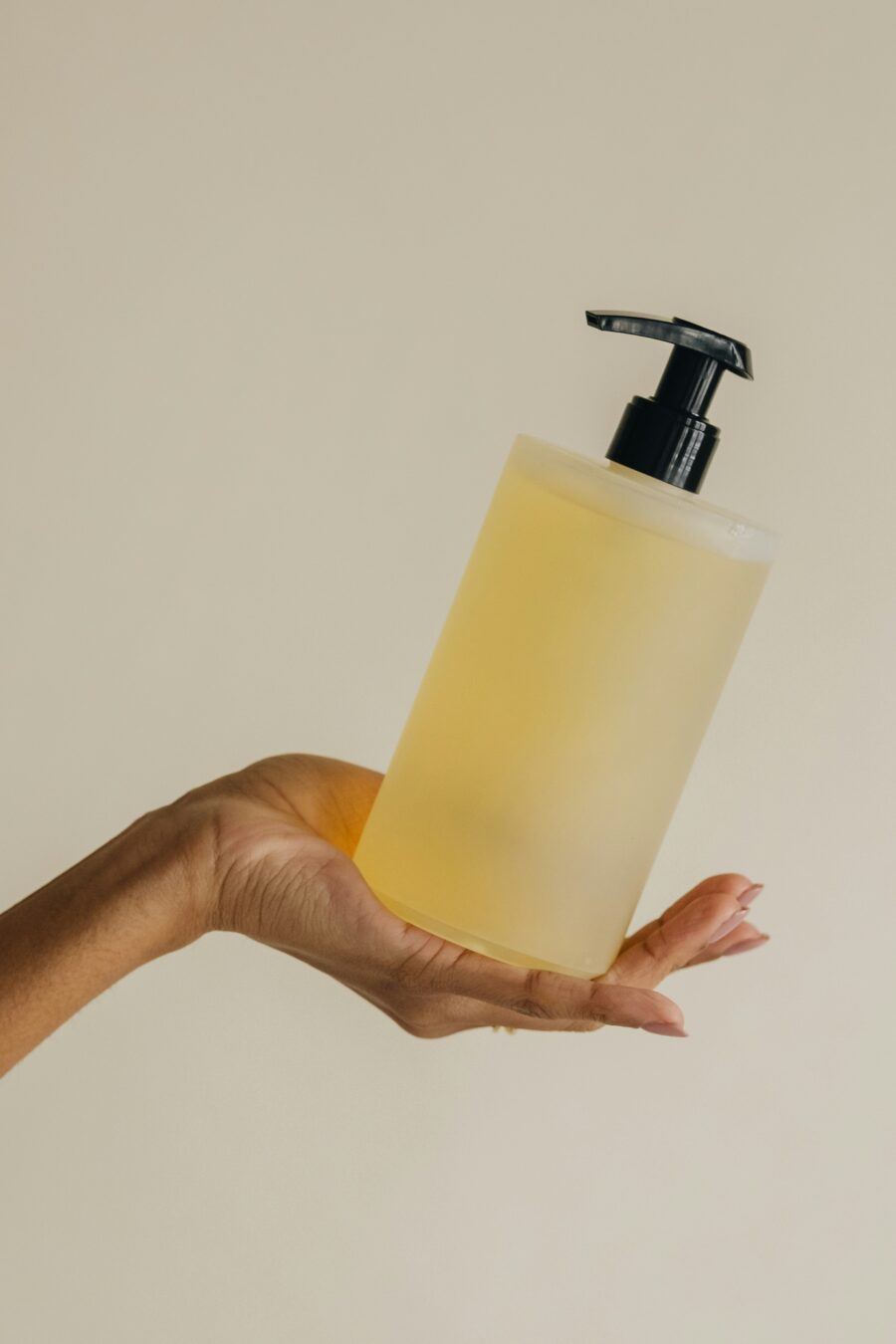 Hand holding a bottle of conditioner in hand.