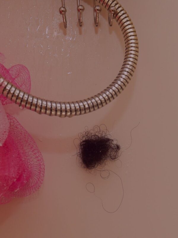 Hair shed rolled up on the shower wall.