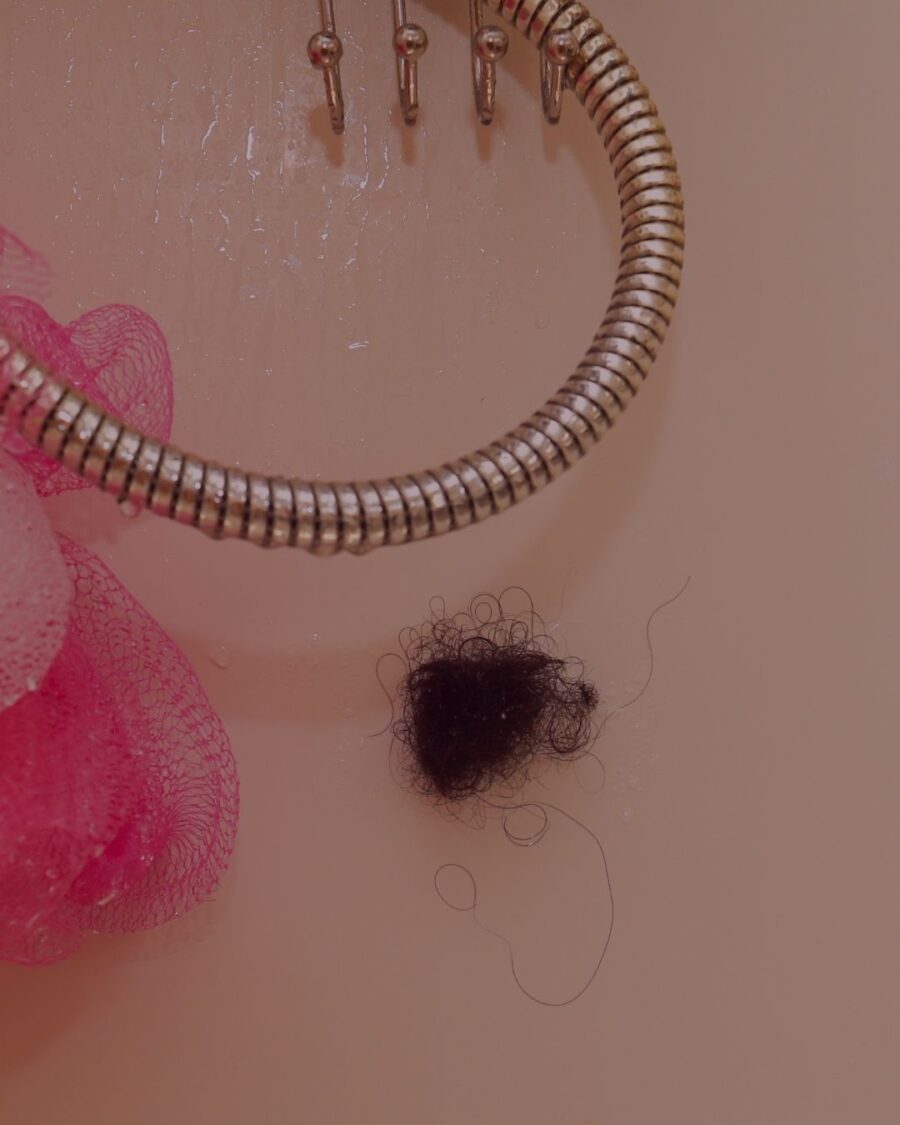 Hair shed rolled up on the shower wall.