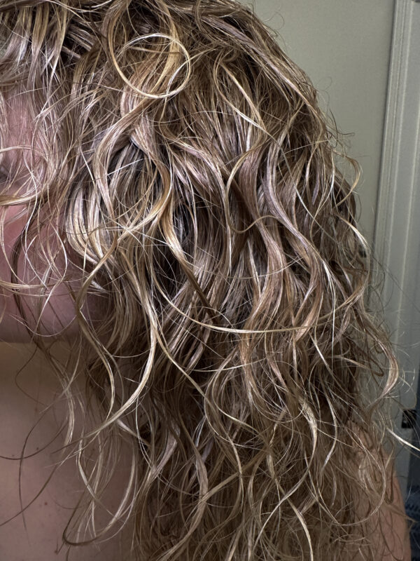 Close up of wet blonde curly hair.