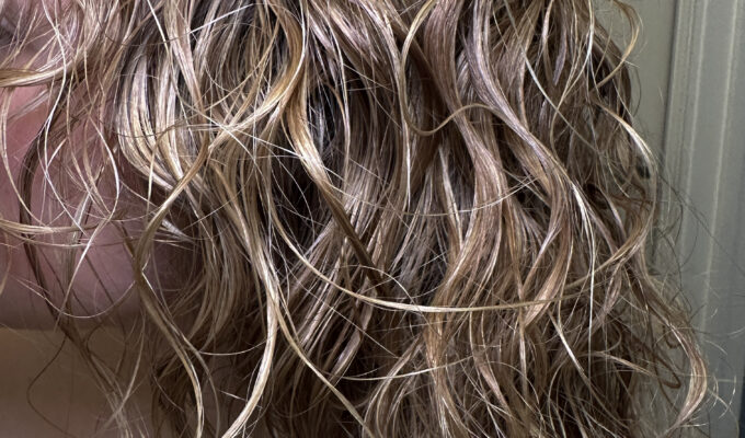 Close up of wet blonde curly hair.