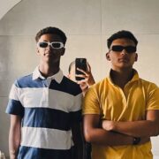 Two men taking a picture in the mirror.