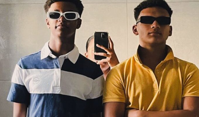 Two men taking a picture in the mirror.