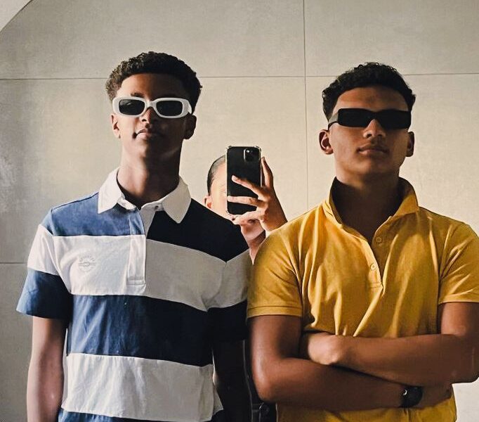Two men taking a picture in the mirror.