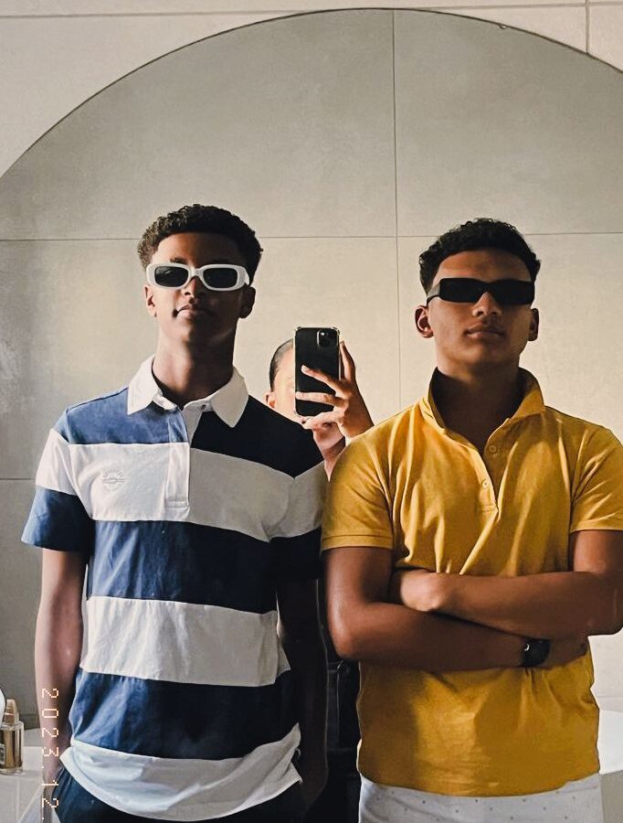 Two men taking a picture in the mirror.