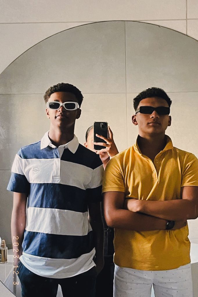 Two men taking a picture in the mirror.