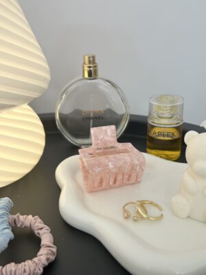 A dish of hair accessories and perfume.