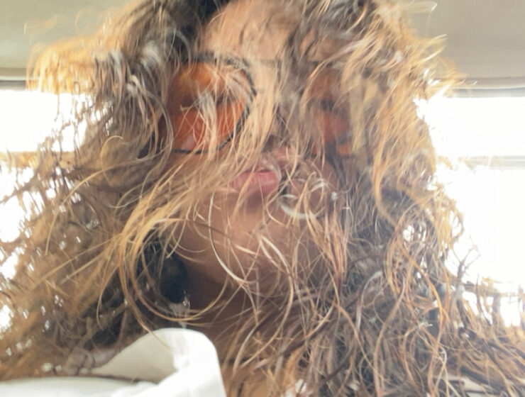 Woman taking a selfie with curly hair.