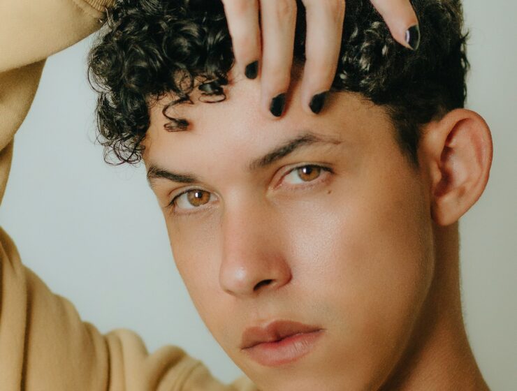 Curly Hair Model Posing with Hand Above Head.