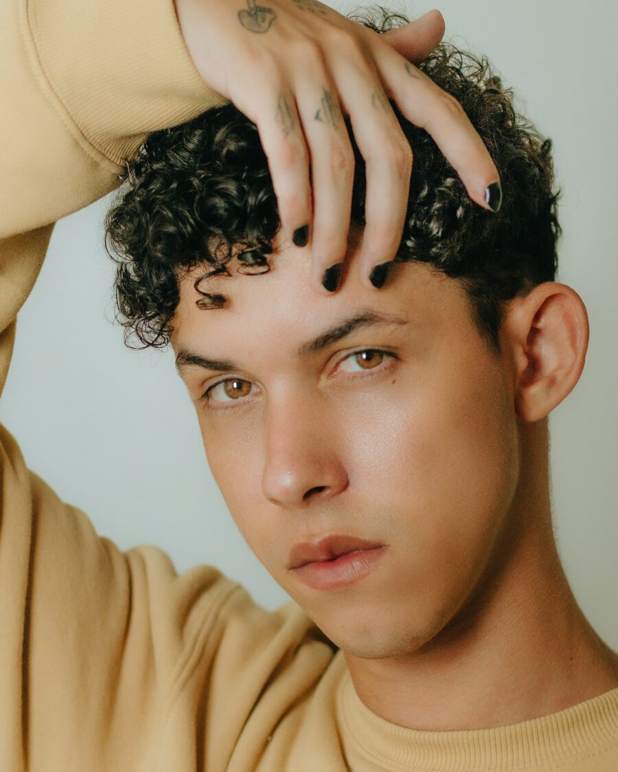 Curly Hair Model Posing with Hand Above Head.