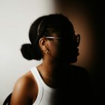 Woman side profile wearing her curly hair in a low bun.