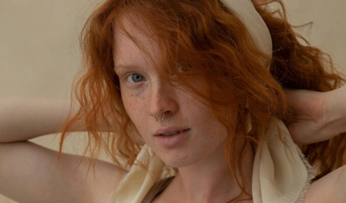 Woman with red hair wearing a hair accessory.