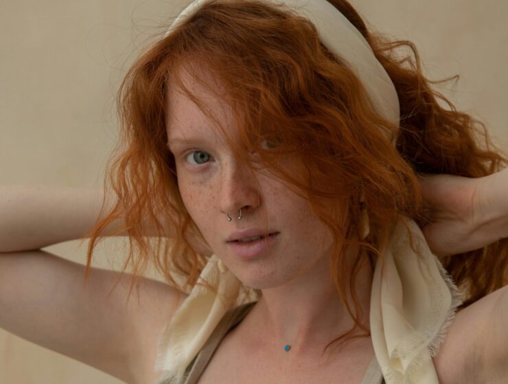 Woman with red hair wearing a hair accessory.
