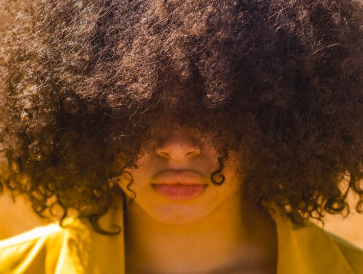 Big curly hair afro covering eyes of face.