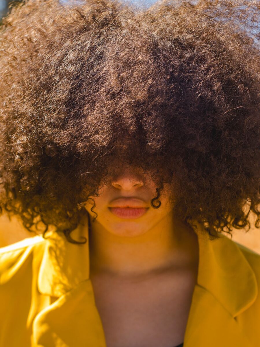 Big curly hair afro covering eyes of face.