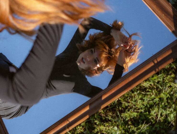 Woman looking in the mirror, where the mirror is placed on the ground.