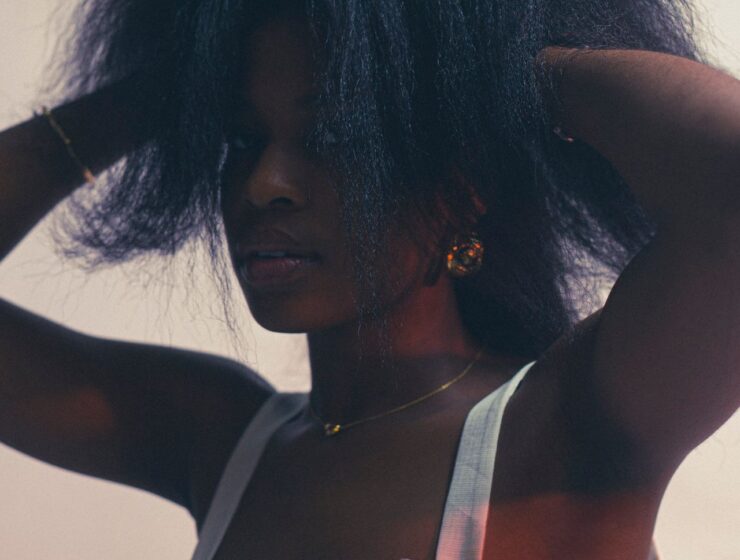 Woman with her hands in her hair, pulling it upwards.