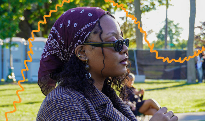 Woman with purple bandana, listening to music at some kinda festival.