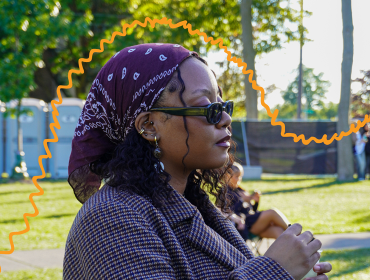 Woman with purple bandana, listening to music at some kinda festival.